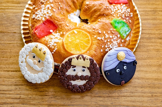 Galletas de los Reyes Magos junto a un delicioso pastel de Navidad español sobre una mesa de madera