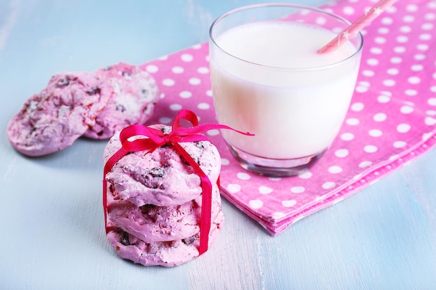 Galletas rosas y vaso de leche en primer plano de la mesa