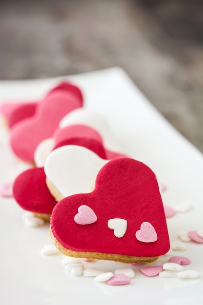 Galletas de San Valentín con forma de corazón en la mesa de madera