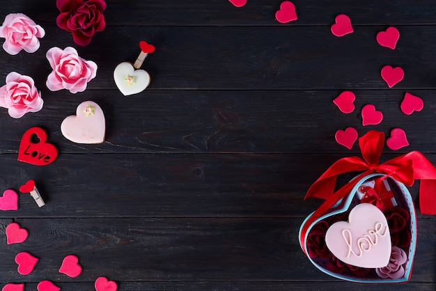 Galletas de San Valentín en forma de corazón sobre fondo de madera oscuro