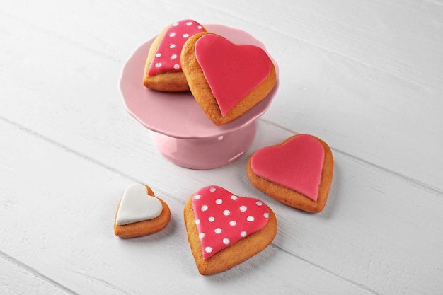 Galletas de san valentín en stand contra fondo de madera