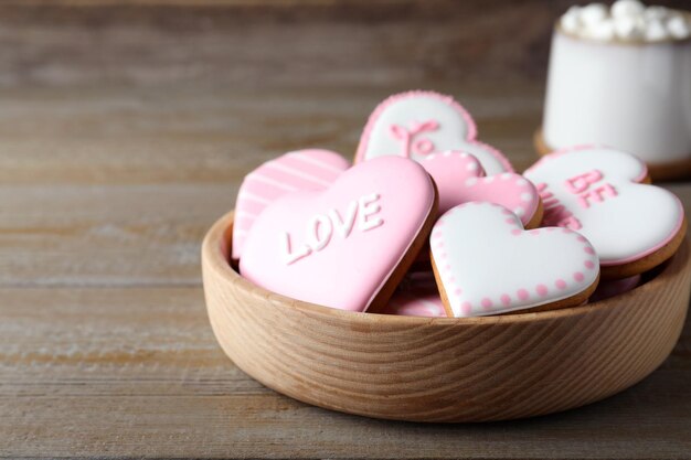 Galletas de san valentín en un tazón sobre una mesa de madera Espacio para texto