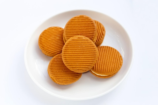 Galletas sándwich de crema pastelera sobre fondo blanco.