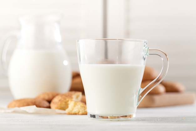 Galletas snickerdoodle recién horneadas con una antigua jarra de leche. Primer plano con iluminación lateral suave y natural.