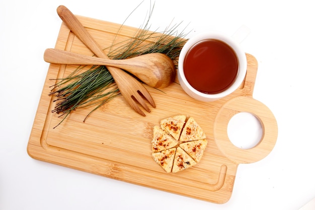 Galletas y taza de té en bandeja de madera