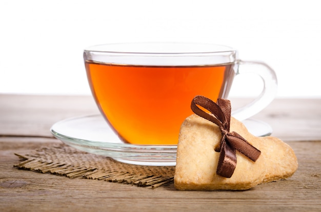 Galletas y una taza de té en la mesa de madera