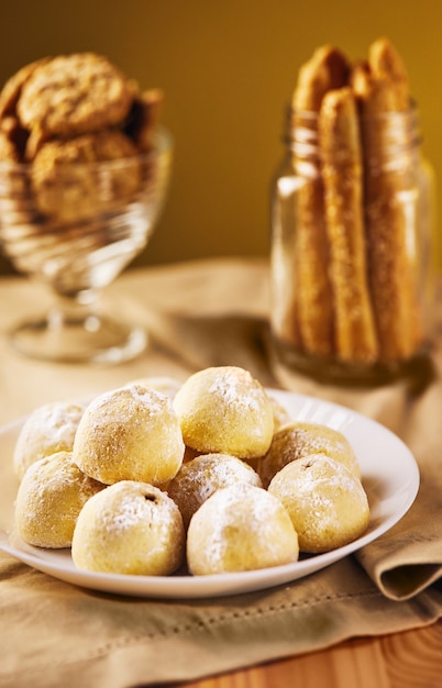 galletas en tonos beige sobre una servilleta en un plato y en un frasco.