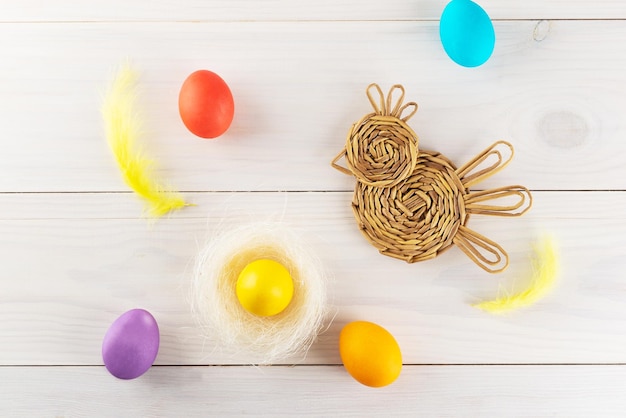 Gallina de mimbre con huevos de Pascua en una mesa de madera Vista superior de orientación horizontal