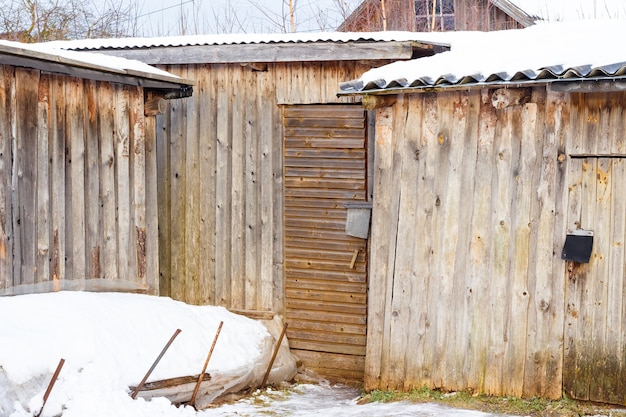 Galpões de madeira em uma vila de inverno coberta de neve