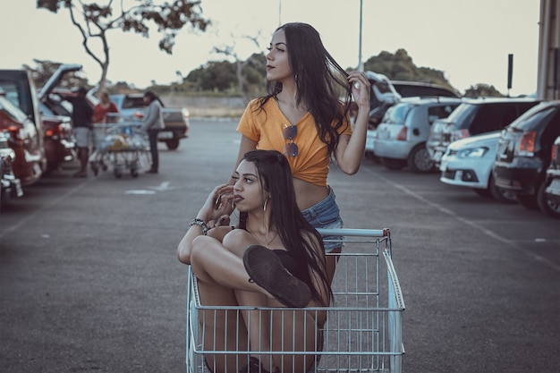 Foto gama / df, brasil, 8 de novembro de 2021, mulheres em um supermercado dentro de um carrinho de compras