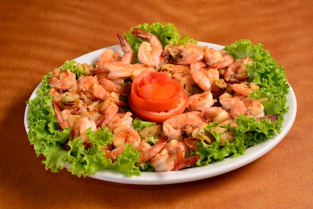 Gambas al ajillo en plato blanco sobre mesa de madera cocina brasileña