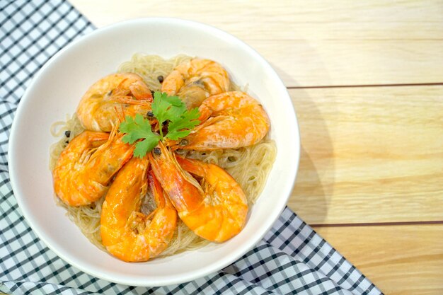 Gambas al horno con fideos en plato blanco