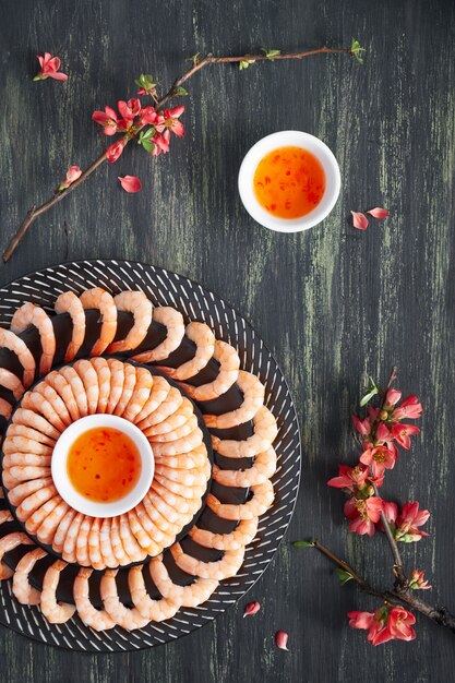 Gambas de limón y ajo picantes servidas en un plato oscuro con dulce