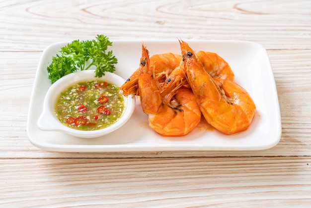 Foto gambas o langostinos salados al horno con salsa picante de mariscos