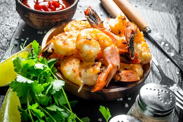 Gambas picantes en un bol con rodajas de perejil y salsa de lima