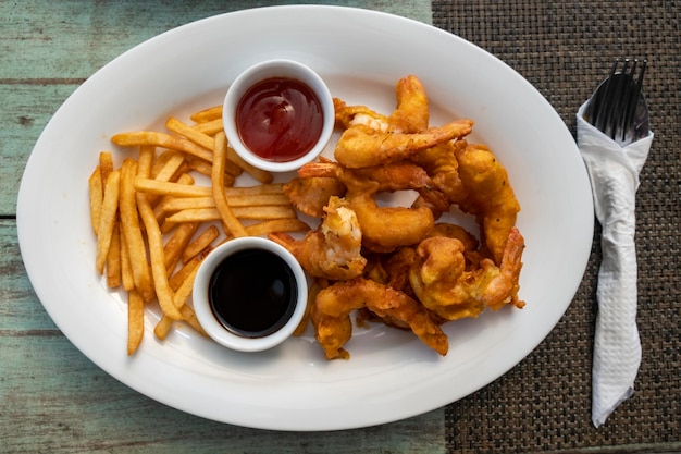 Gambas rebozadas con patatas fritas en mesa