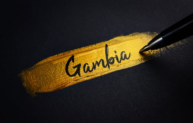 Gambia-Handschrift-Text auf goldenem Pinsel-Anschlag