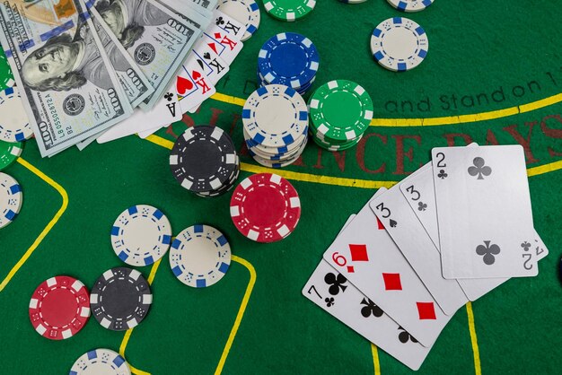 Gamble Poker-Konzept Spielkarten, Chips und Dollars sind um den neuen Pokertisch herum verstreut