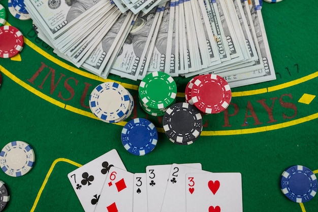 Gamble Poker-Konzept Spielkarten, Chips und Dollars sind um den neuen Pokertisch herum verstreut