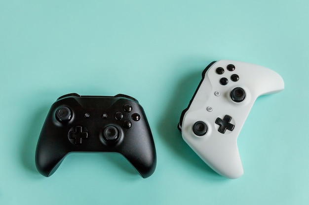 Gamepad de dos joysticks blanco y negro, consola de juegos aislada sobre fondo azul pastel
