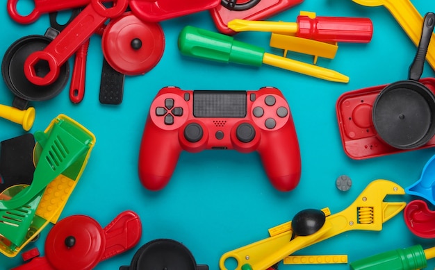 Gamepad y muchos juguetes para niños en un azul.