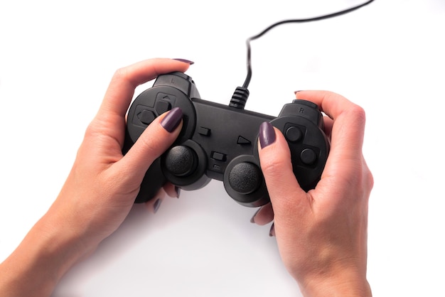 Gamepad preto nas mãos femininas em um fundo branco, jogos, conceito de entretenimento competitivo