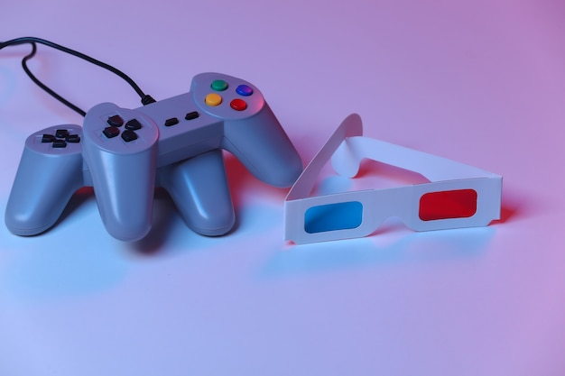 Gamepads retrô com óculos 3D em luz de néon azul vermelha. Atributos anos 80
