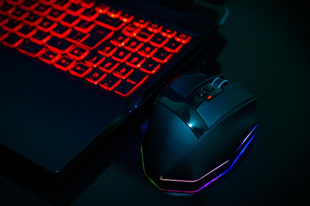 Gamer de mouse e notebook isolado em mesa preta