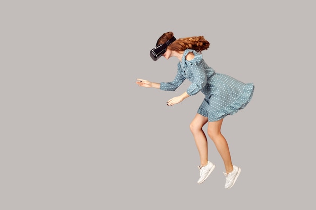 Gamer-Mädchen schwebt in der Luft, schwebt mit Virtual-Reality-Brille, spielt Spiel durch vr
