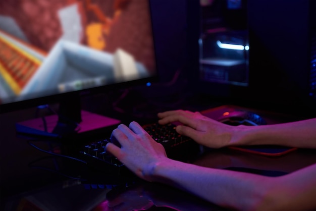 Gamer spielen Computerspiel mit rgb-neonfarbener Tastatur