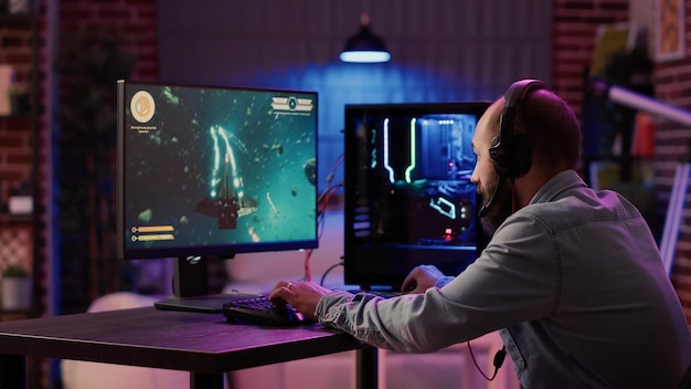 Gamer-Streaming-Wettbewerb im Online-Weltraum-Shooter, der enttäuscht ist, nachdem er zu Hause auf dem Gaming-PC verloren hat. Mann spielt Internet-Multiplayer-Spiel traurig, nachdem er schwieriges Level im Turnier nicht bestanden hat.