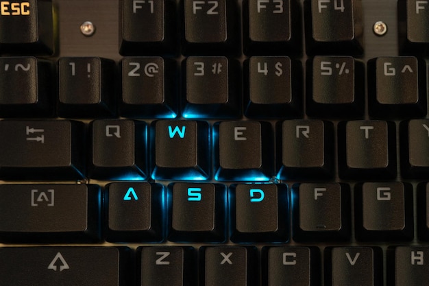 Gaming-Tasten auf der Tastatur mit blauer Hintergrundbeleuchtung, Nahaufnahme