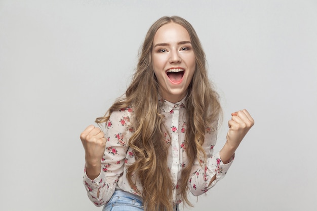 Gana un grito de mujer rubia emocional y ten una mirada de felicidad y una sonrisa con dientes