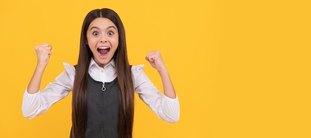 El ganador de la adolescente feliz da un gesto ganador celebrando la victoria fondo amarillo ganó Cartel horizontal de la cara del niño adolescente aislado banner de retrato con espacio de copia