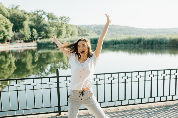 Ganador como estilo de vida tiro horizontal de joven hermosa mujer en ropa deportiva sonriendo mientras pa