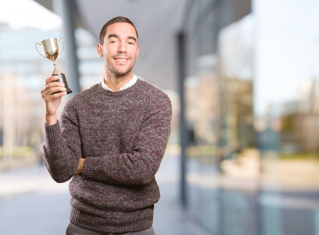 Ganador joven sosteniendo una taza de oro