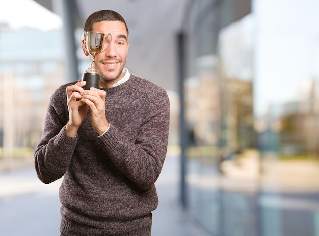 Ganador joven sosteniendo una taza de oro