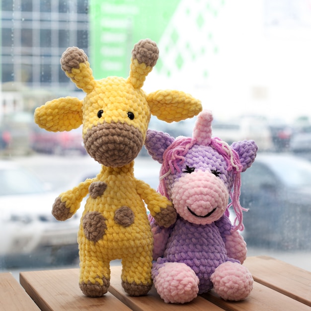 Ganchillo amigurumi jirafa amarilla y unicornio. Juguete de punto hecho a mano.