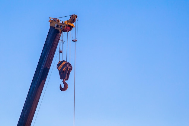 Gancho do guindaste de torre fechado contra o céu azul