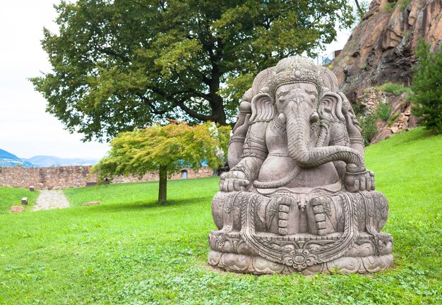 Ganesha-Statue aus Stein mit einem wunderschönen Berggarten im Hintergrund