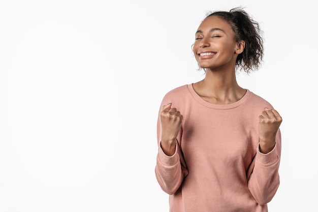 Ganhando sucesso mulher feliz comemorando ser vencedor sobre fundo branco