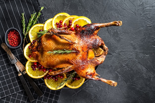 Ganso al horno relleno de naranjas y romero. Mesa festiva