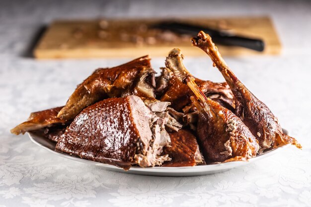 Ganso asado en porciones en un plato blanco Cerrar