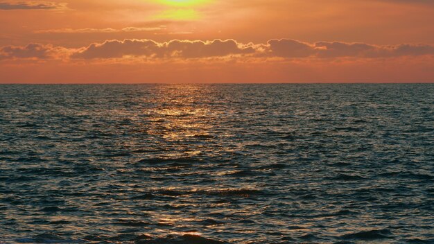 Ganz Hintergrund des Meeres bei Sonnenuntergang mit orangefarbenen Reflexionen abstrakte goldene Reflexion auf dem Wasser Sonnenondergang