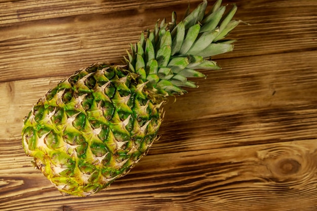 Ganze Ananas auf Draufsicht des Holztischs