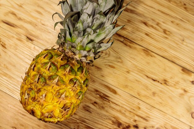 Ganze Ananas auf Holztisch. Ansicht von oben, Textfreiraum