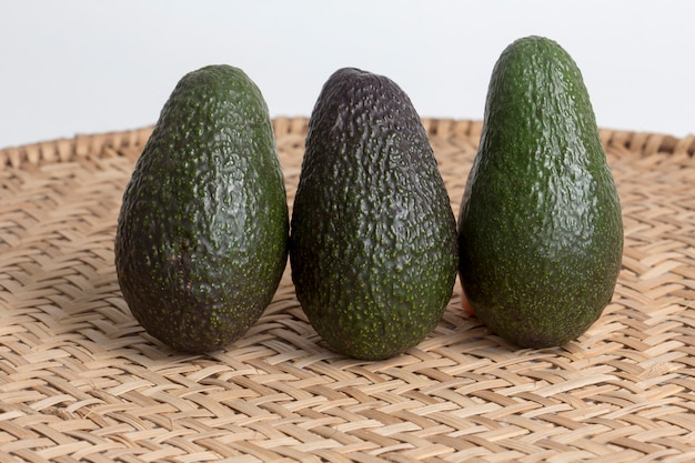 Foto ganze avocados auf korbsieb