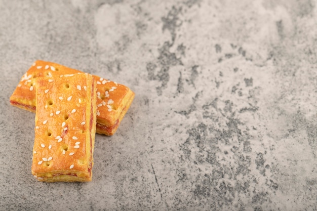 Ganze Cracker mit Sesam auf einem Steintisch.