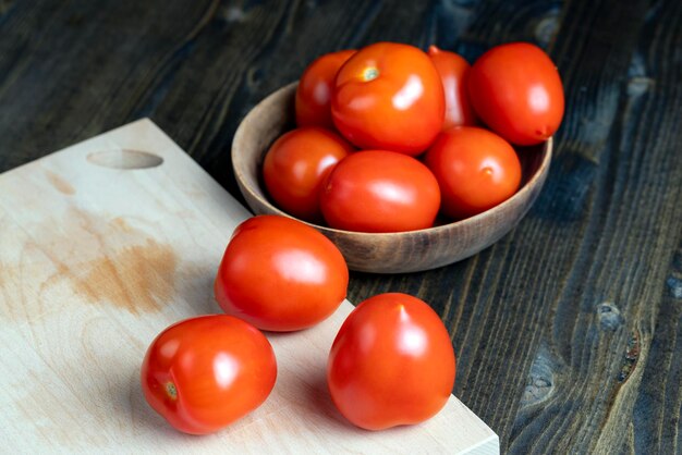 Ganze frische Tomaten in einer Holzschale