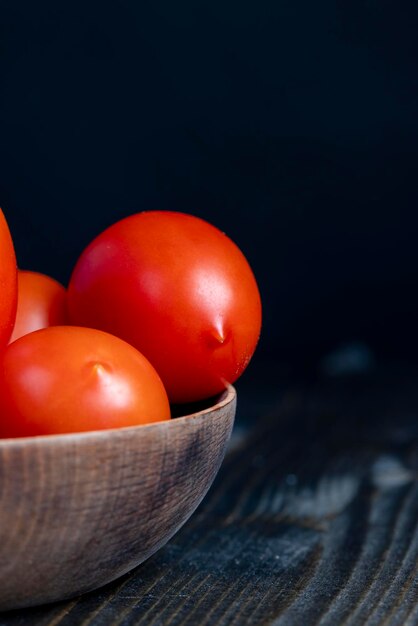 Ganze frische Tomaten in einer Holzschale